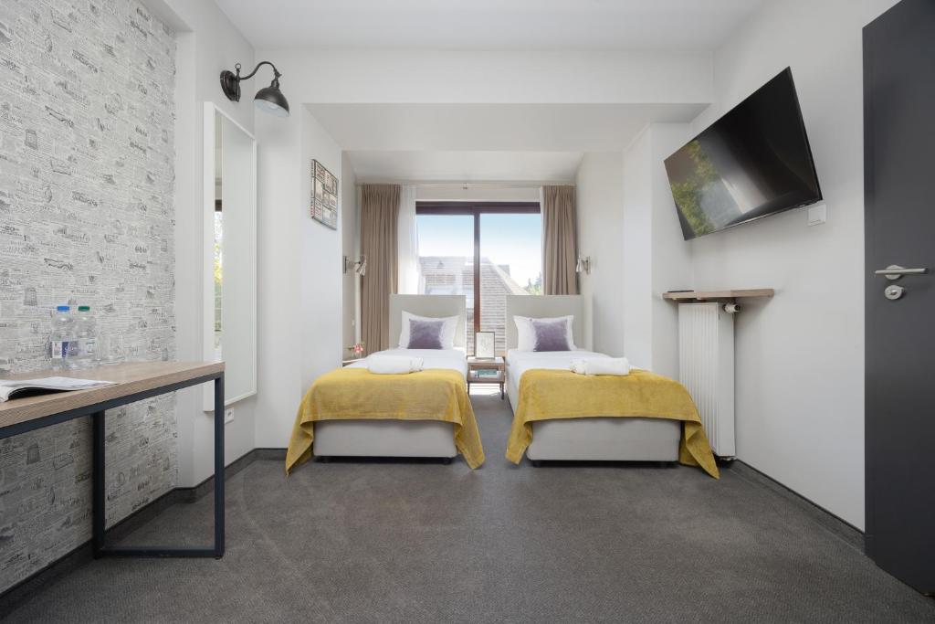 a hotel room with two beds and a sink at Kremowa Residence by Solarento in Warsaw