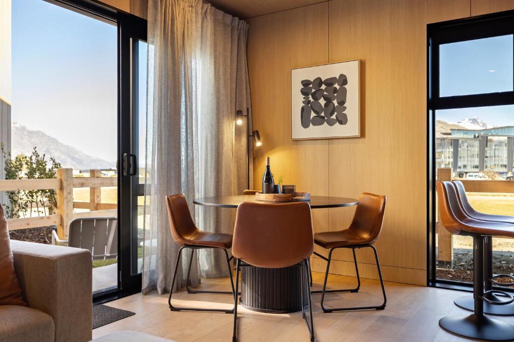 een kamer met een tafel en stoelen en een balkon bij Tahuna Luxury Villa Queenstown in Queenstown