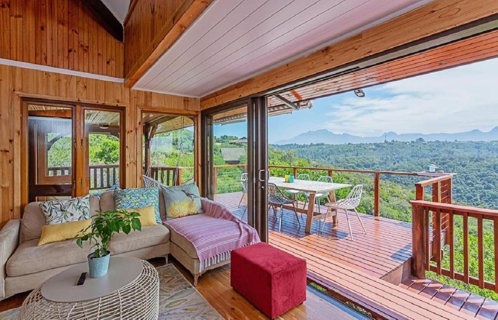 Loerie's Rest Cabin في خليج فيكتوريا: غرفة معيشة مع أريكة وطاولة على السطح