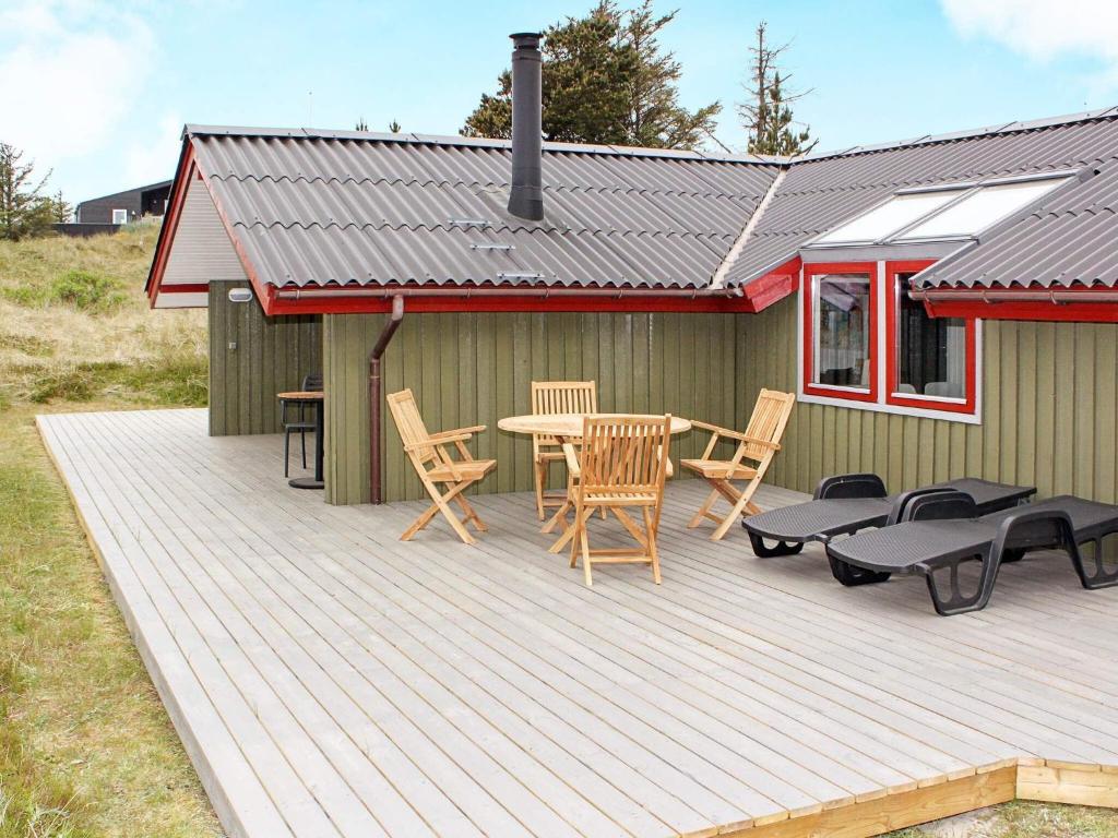 a wooden deck with a table and chairs on it at Modern Cottage by Dunes - By Traum Ferienwohnungen in Vejers Strand
