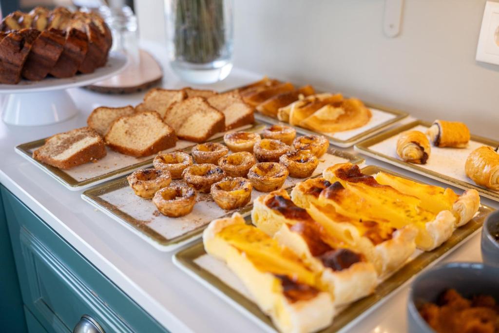A close-up of a breakfast spread featuring pastries, sliced cakes, and tarts.