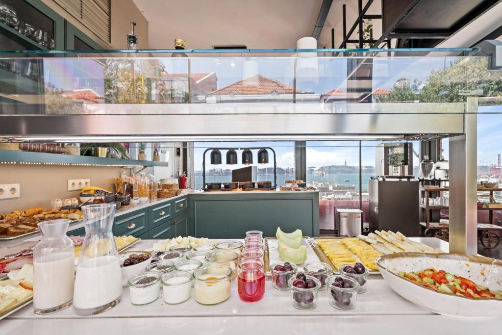A generously presented breakfast counter with fresh fruit, yogurt, drinks, and pastries.