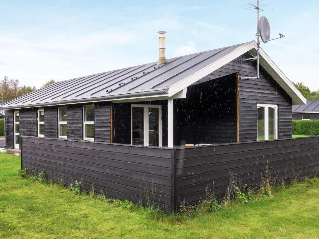 a black house with a gambrel roof at 6 person holiday home in Hals-By Traum in Hals