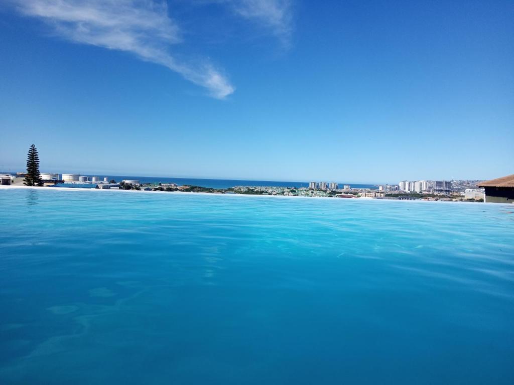 una gran masa de agua con una ciudad al fondo en Island View Room, en Mossel Bay