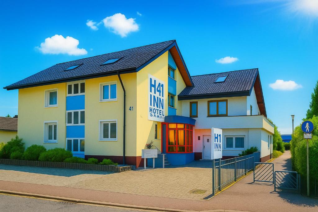 a large yellow building with a sign on it at H41 Inn Hotel Garni Freiburg in Freiburg im Breisgau
