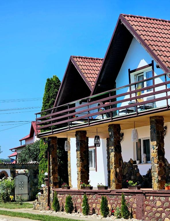 una casa con un balcón encima en Mera Holiday Inn, en Albeştii Pămînteni