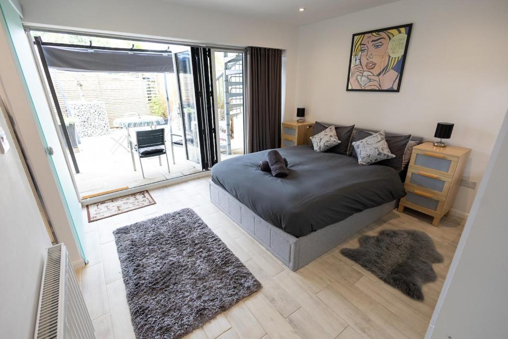 a bedroom with a bed and a large window at Davids Dairy in Kings Cliffe