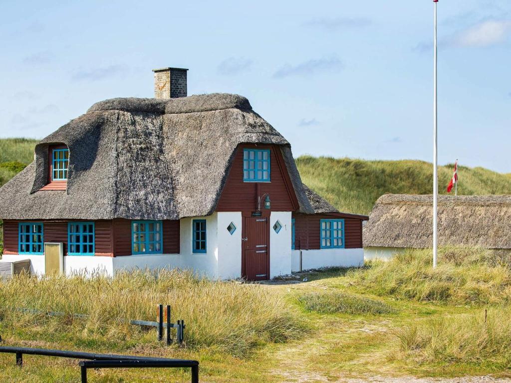 a house with a thatched roof on a beach at Charming Seaside Cottage - By Traum Ferienwohnungen in Fjand Gårde