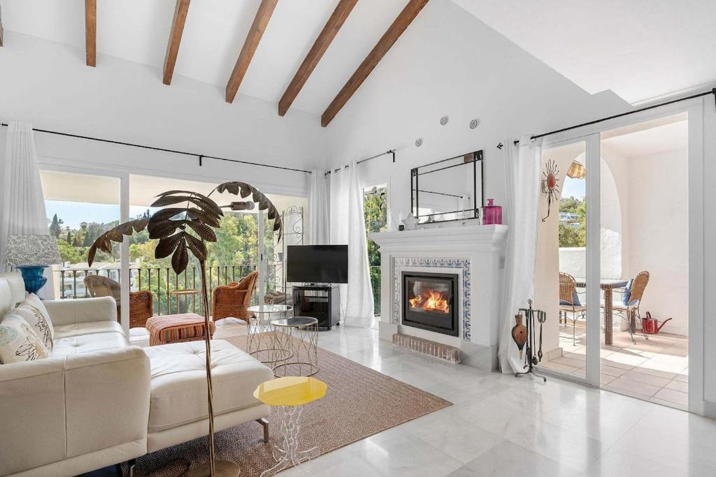 a living room with a couch and a fireplace at Beautiful Golfside Hideaway in Benahavís