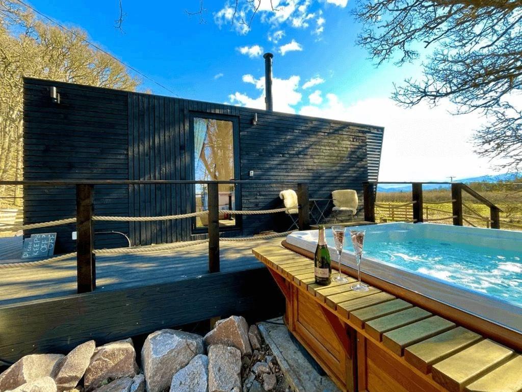 a swimming pool with a hot tub in a house at Dog friendly cabin & hot tub and Cairngorm views in Aviemore