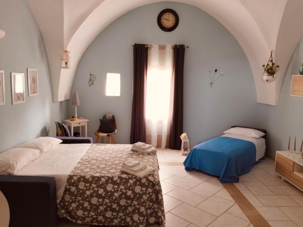 a bedroom with a bed and a clock on the wall at Casa vacanze Vista Castello in Oria