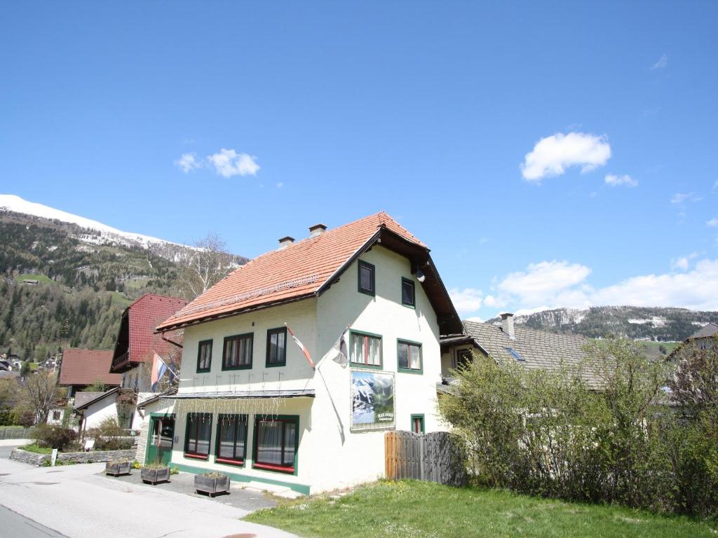 a white house with a red roof on a street at Apartment in St Michael near Ski Slopes in Sankt Michael im Lungau