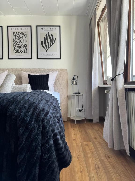 a bedroom with a bed with a black blanket at RheinLoft Apartment - Balkon & Parkplatz "optional" am Deutschen Eck in Koblenz