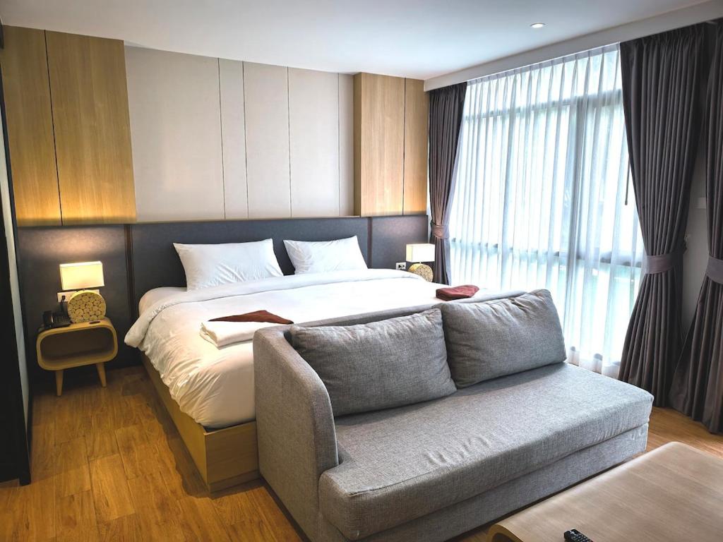 a hotel room with a bed and a couch at Wyndham Garden Studio Apartment in Nai Thon Beach