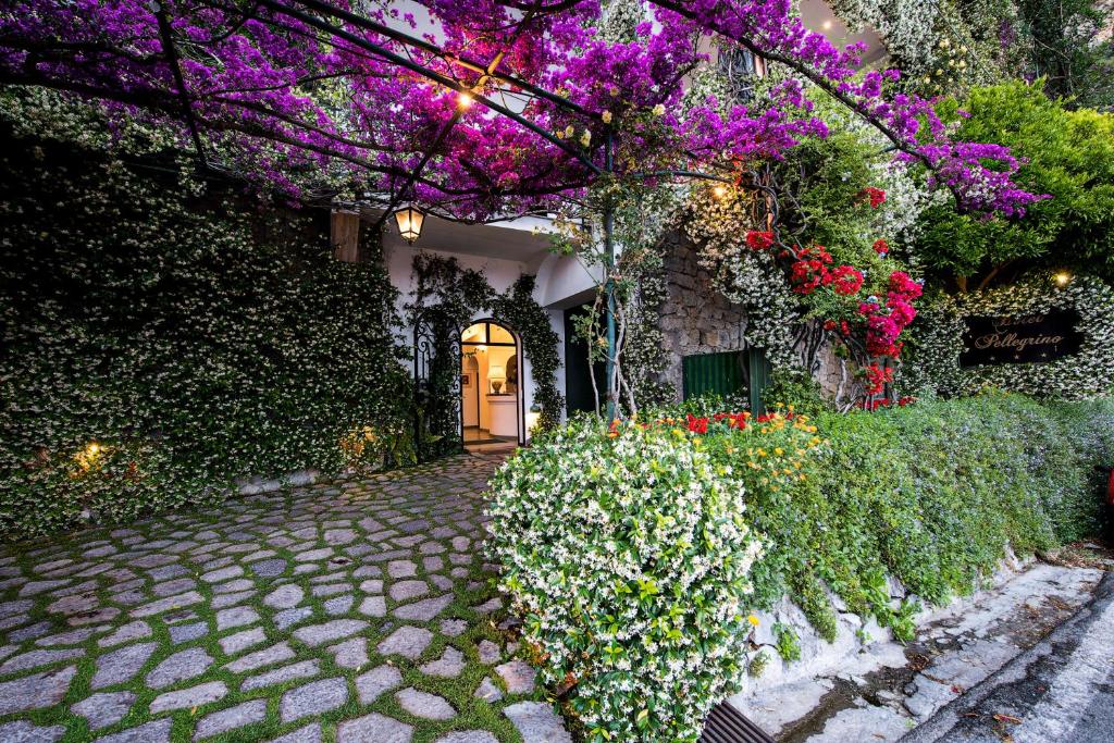 een huis met paarse bloemen en een loopbrug bij Hotel Pellegrino in Praiano