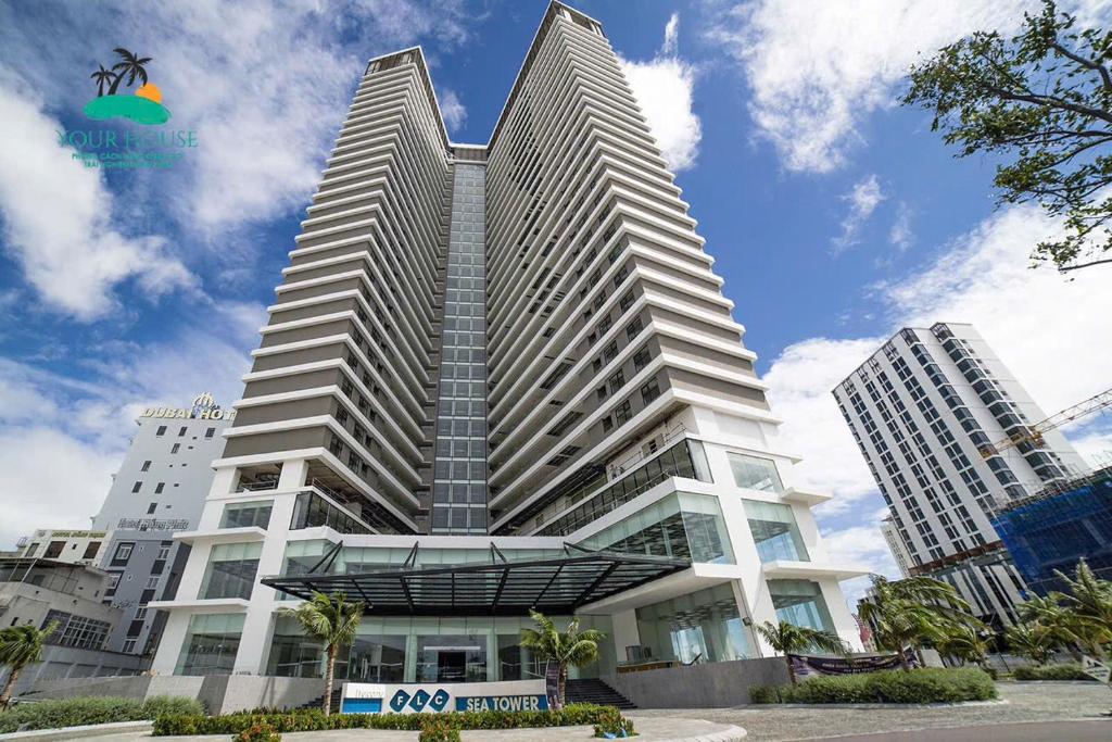 a tall white building with two tall buildings at FLC Sea Tower Quy Nhon Official in Quy Nhon