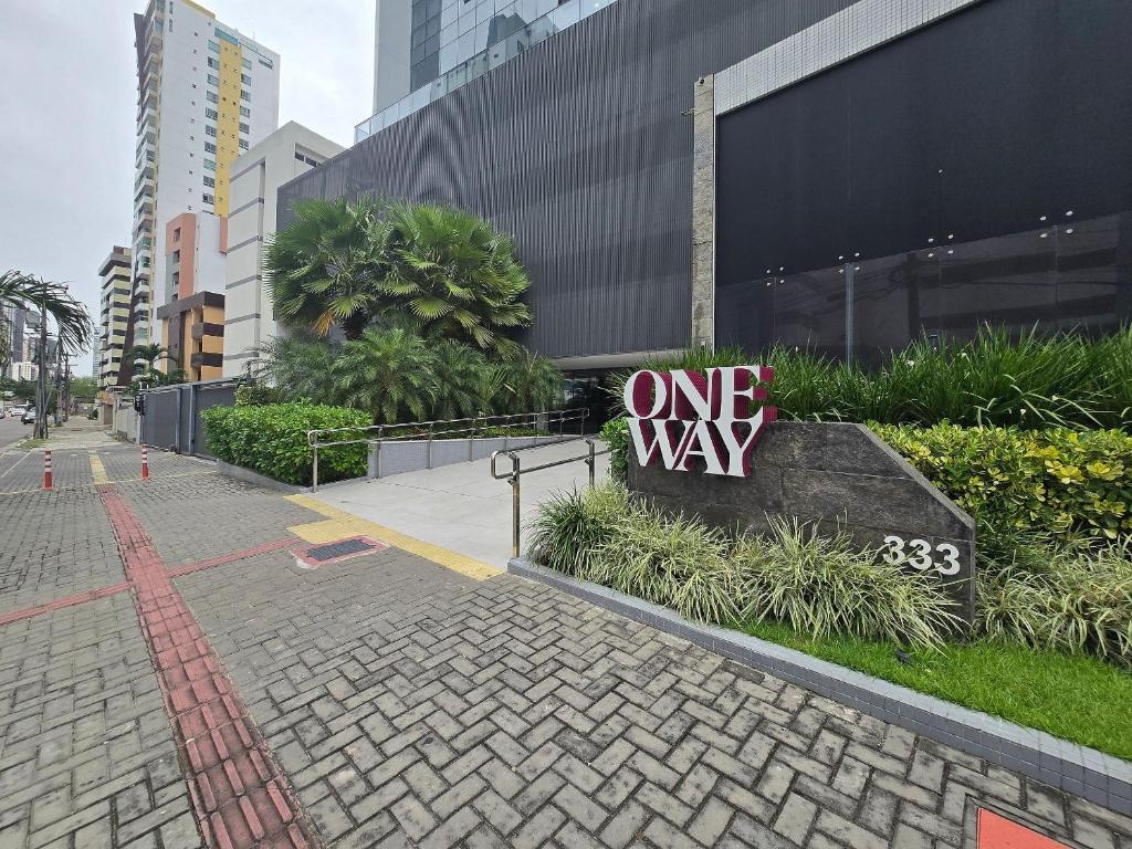 a one way sign on a sidewalk in a city at One Way by Hosppedar in Tambaú