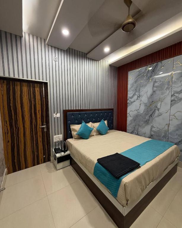 a bedroom with a large bed with blue pillows at Hotel Archit International in Jāmb