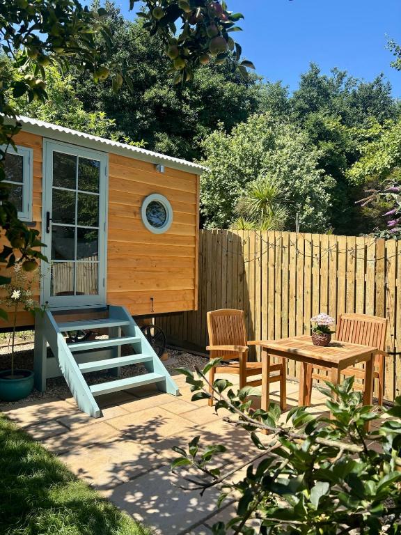 a backyard with a tiny house and a table at Sea Spray in St Austell
