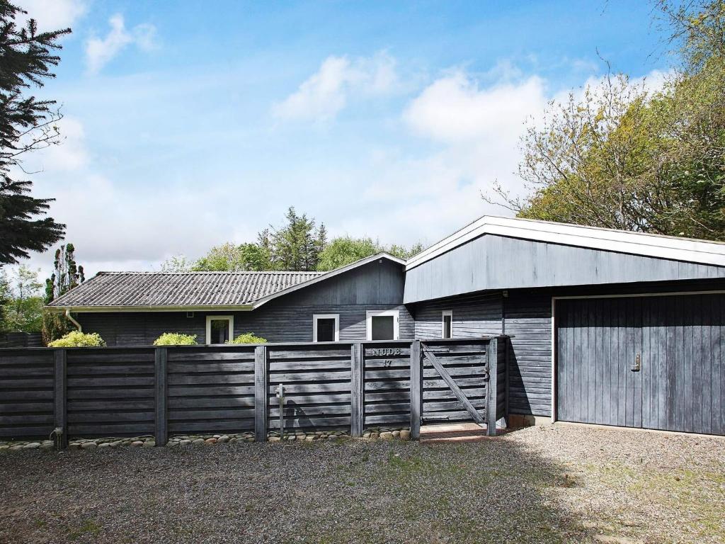 a house with a fence and a barn at Seaside Charm in albaek - By Traum Ferienwohnungen in Spottrup