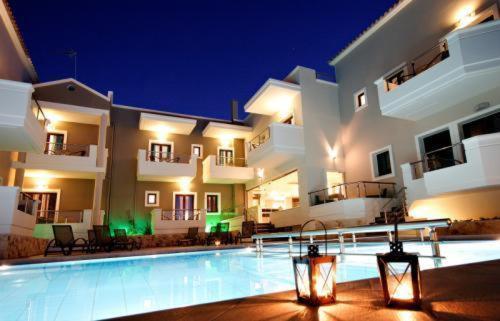 a large house with a swimming pool at night at Theros Hotel in Tavronitis
