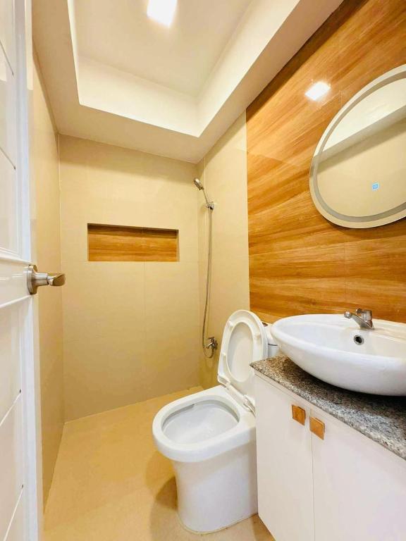 ein Badezimmer mit einer weißen Toilette und einem Waschbecken in der Unterkunft Elegant 3 Bedroom House near Airport in Sampong