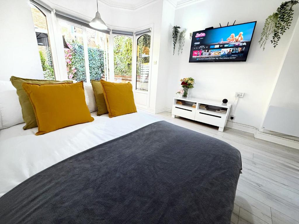 a bedroom with a bed with a tv on the wall at Luxurious Apartment with Patio in Covent Garden in London