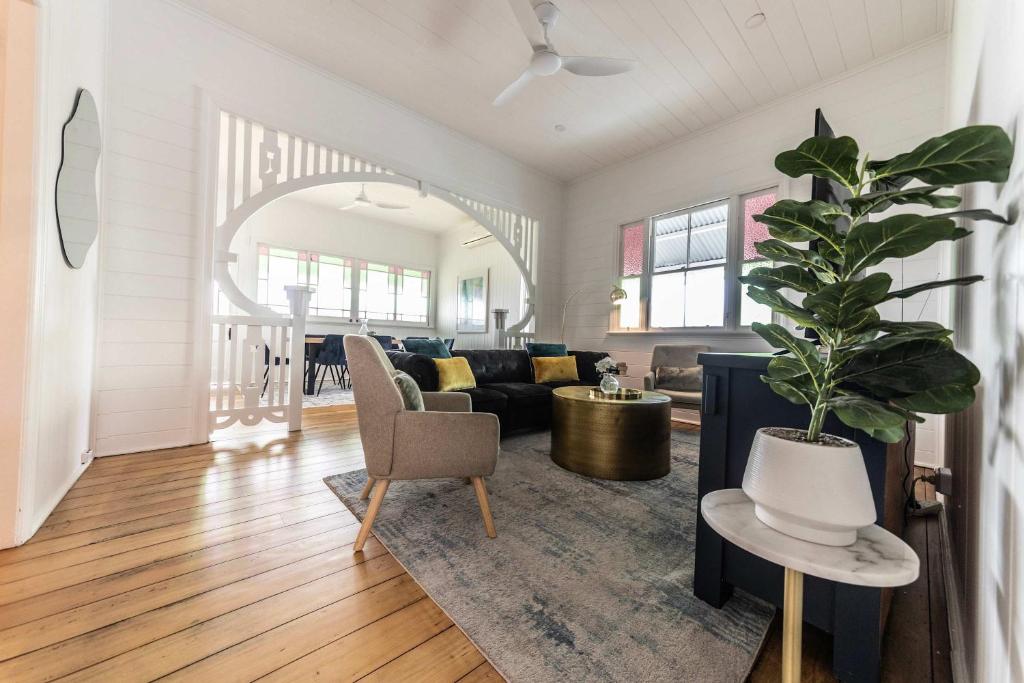 a living room with a couch and a potted plant at Urban Getaway Colonial 6 beds 2 bath aircon pet family in Bundamba
