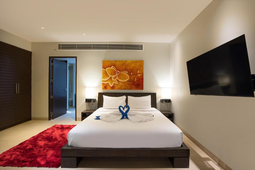 a bedroom with a bed with a blue ribbon on it at Tropical Serenity - Elegant 1 Bedroom with Pool in Ban Saiyuan (1)