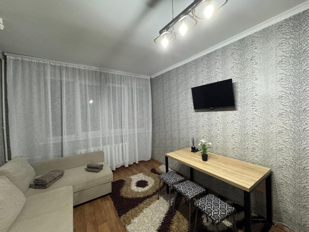 a living room with a table and a couch at Chișinău Airport Comfort in Chişinău