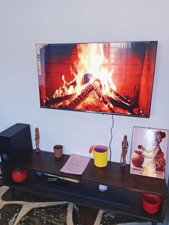 Ukunda AirportにあるDevkim staysの暖炉のあるテーブルとその上にコンピューターが置かれている