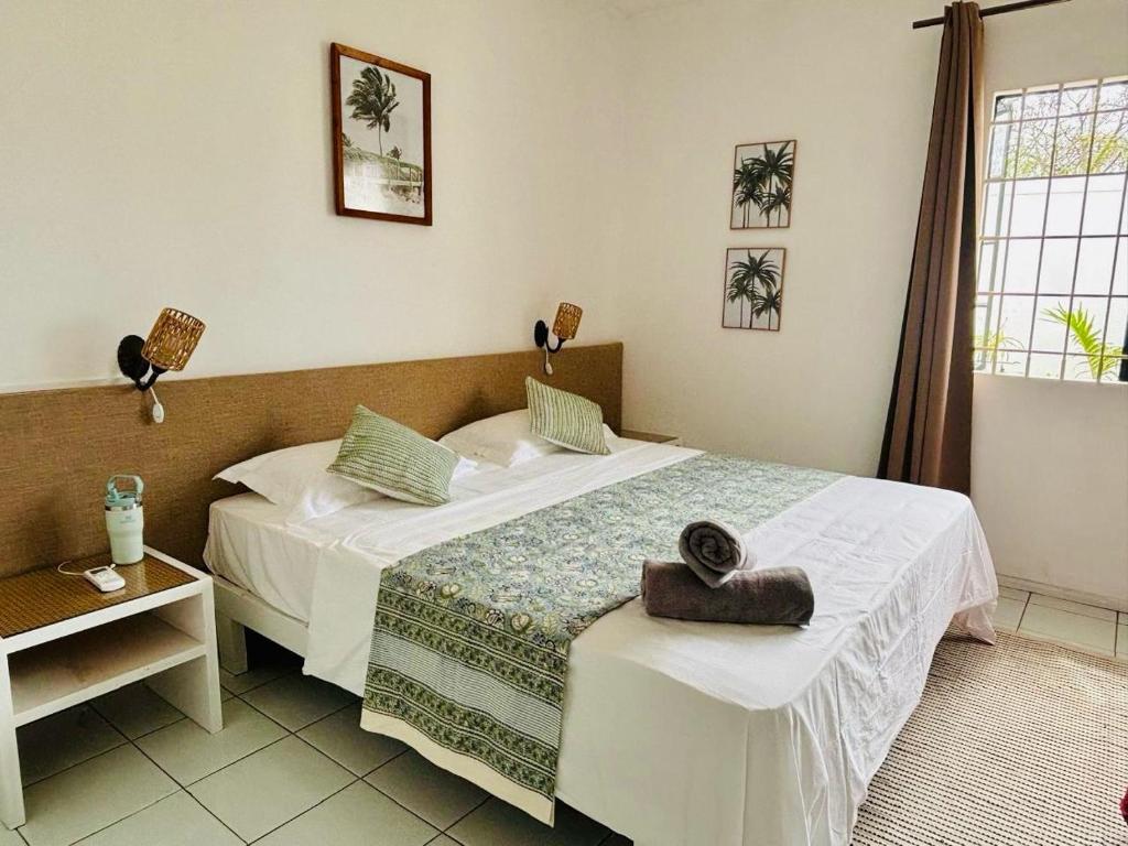 a hotel room with two beds and a table at Mont Choisy Lodge - Coco Apartment in Trou aux Biches
