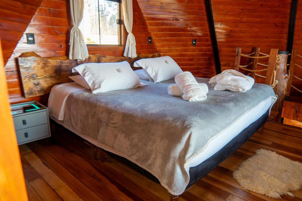 ein Schlafzimmer mit einem Bett mit Handtüchern darauf in der Unterkunft Chalé Boutique Spa- Sauna seca, Jacuzzi , Rede suspensa in Campos do Jordão