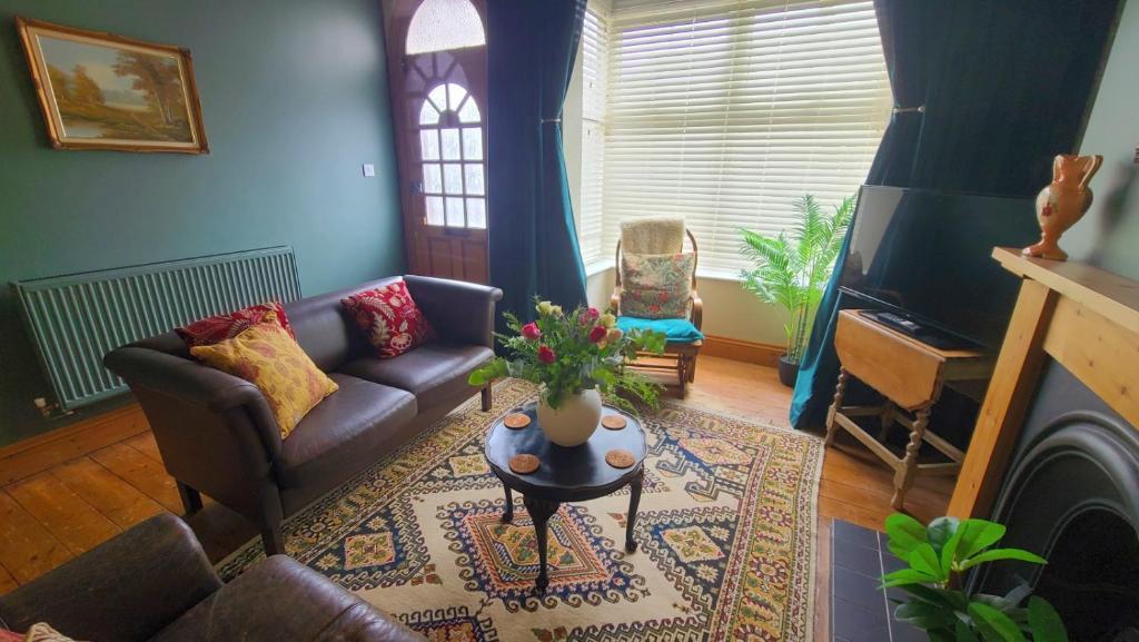a living room with a couch and a table at Druids Cottage a cosy 2 bedroom Cottage within a 5 minute drive from Cannock town centre in Great Wyrley