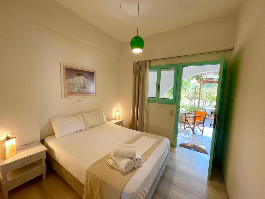 una habitación de hotel con una cama y un balcón en Lilo's Apartments, en Livadi Astypalaias