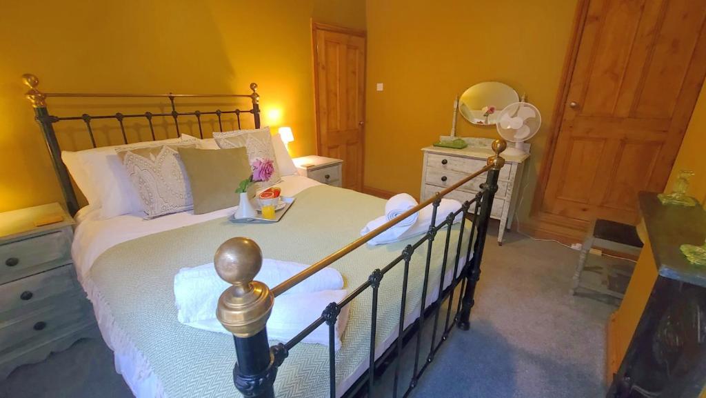 ein Schlafzimmer mit einem Bett mit weißen Laken und einem Spiegel in der Unterkunft Cosy 2 bedroom Cottage within a 5 minute drive from Cannock town centre in Great Wyrley