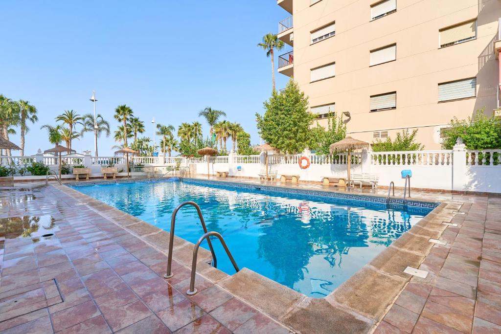 a swimming pool in front of a building at Aurora Mar Del Sol in Almuñécar