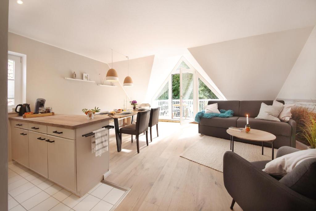 une cuisine et un salon avec un canapé et une table dans l'établissement Im Bad, strandnah und zentral, à Sankt Peter-Ording