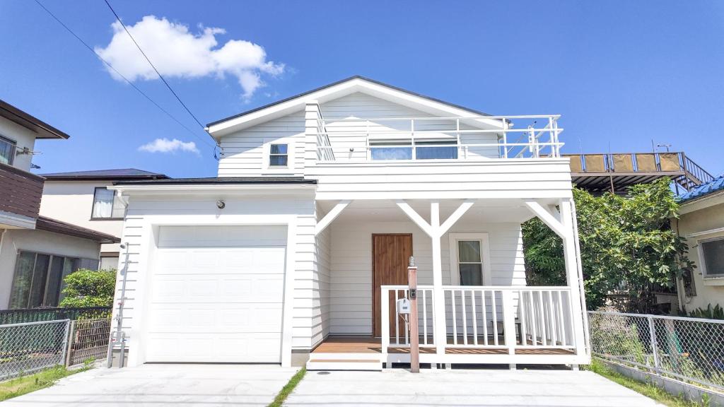 a white house with a white garage at 9Stay辻堂 in Chigasaki