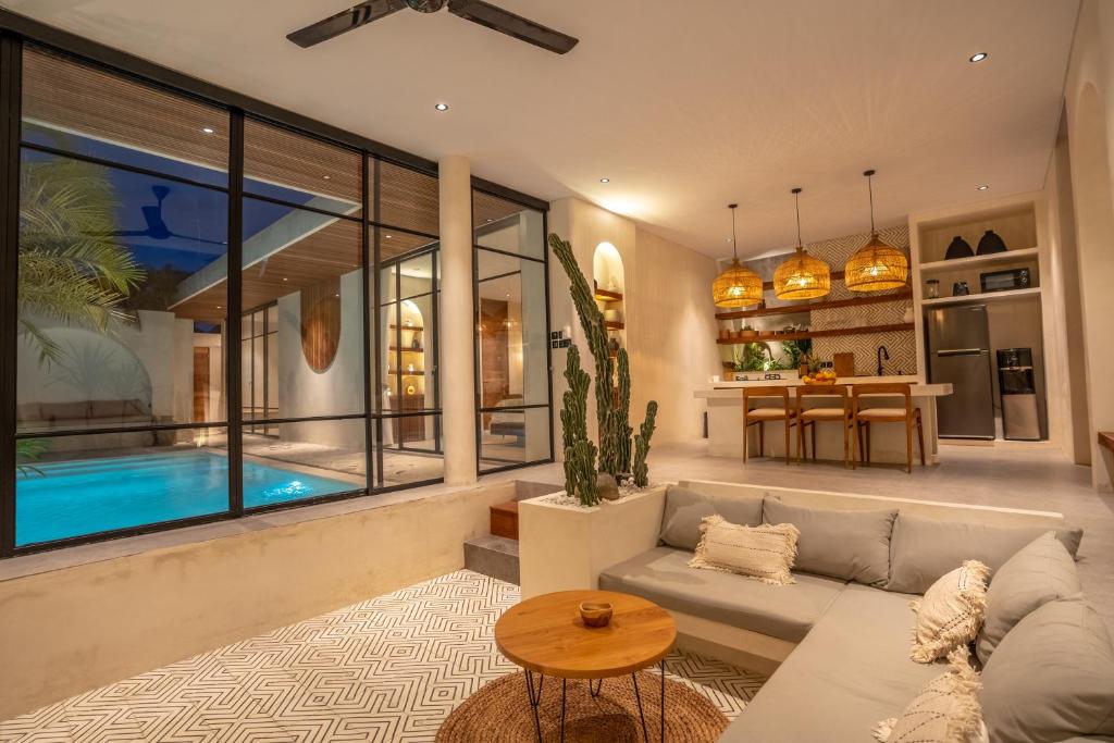 a living room with a couch and a swimming pool at Your Romantic Mediterranean Villa in Canggu in Dalung