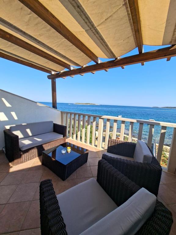 un patio con sofás y vistas al océano. en Apartman NoTi, en Milna