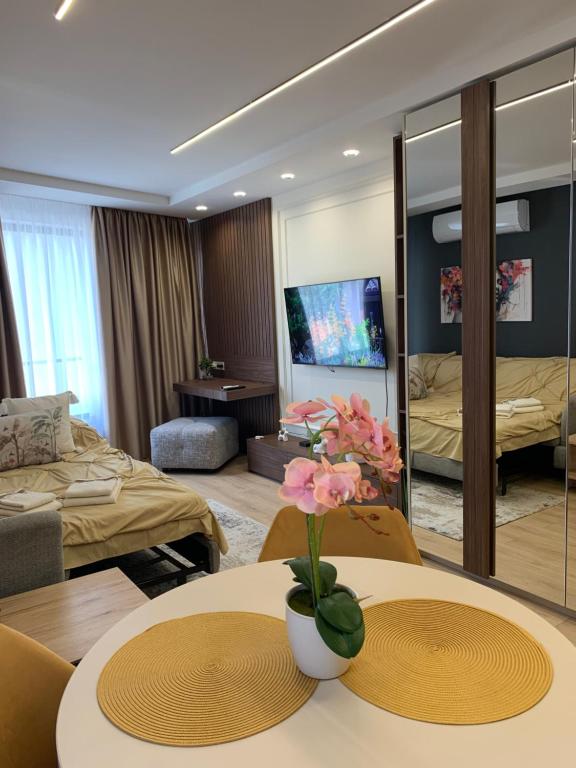 a hotel room with two tables and a living room at The Modern Nest Apartment with FREE Underground Parking in Plovdiv