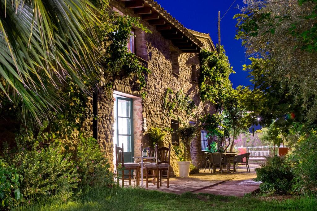 una casa de piedra con mesa y sillas al aire libre en Villa Rotonda en Alquerías del Niño Perdido