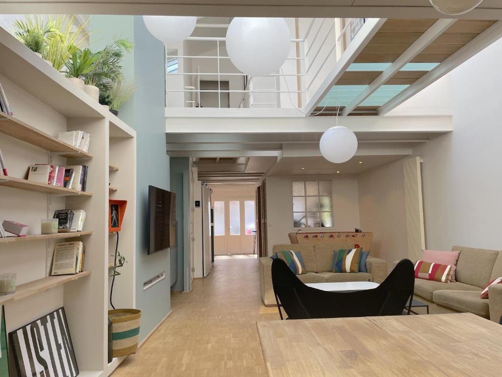 a living room with a table and chairs at LOFT maison 5ch 5sdb 5wc Lille 200m2 avec extérieur in Lambersart