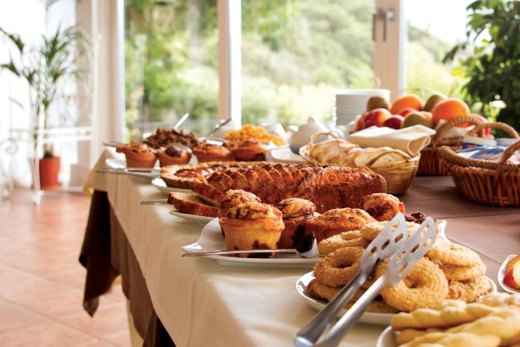 un buffet de bollería y fruta en una mesa en Antica Tindari, en Patti