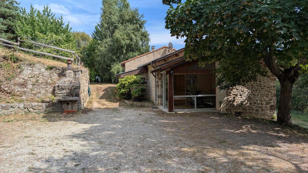 Maison de vacances en Ardèche في Pailharès: مبنى حجري قديم بجانبه شجرة