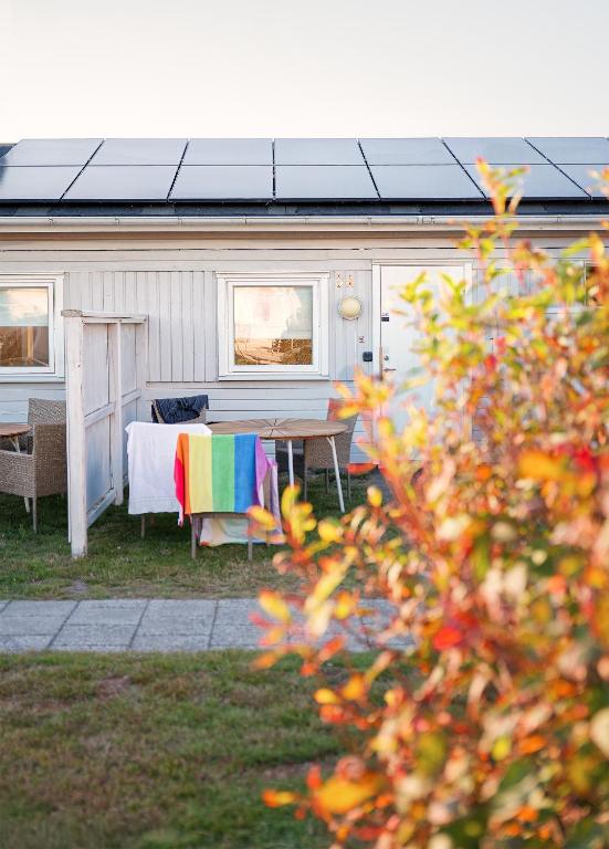 a caravan with a table and a rainbow blanket at Apelvikstrand Lägenheter in Varberg