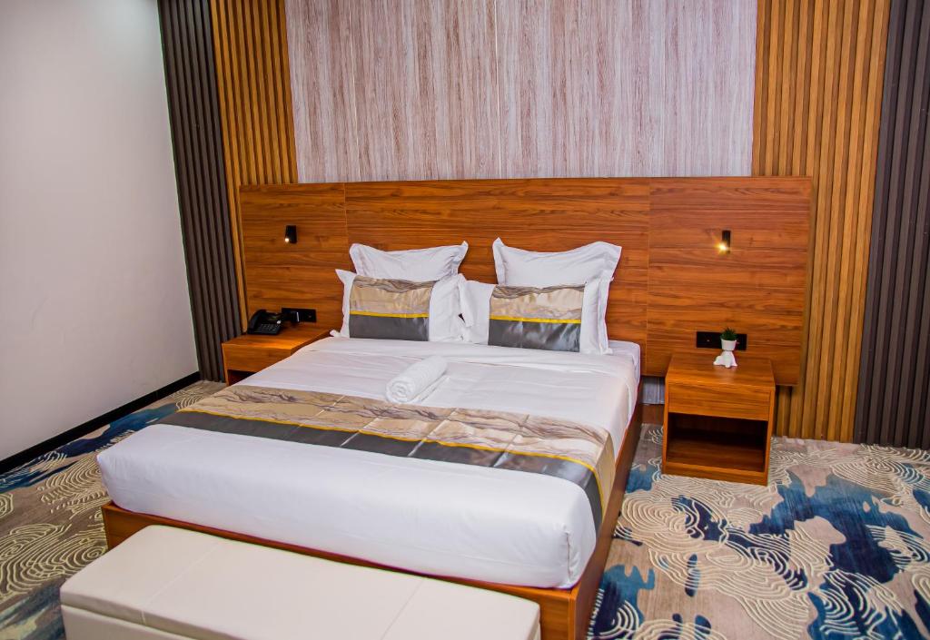 オンダングワにあるEmirates Hotelの木製のヘッドボードが付いた大きなベッドのある寝室