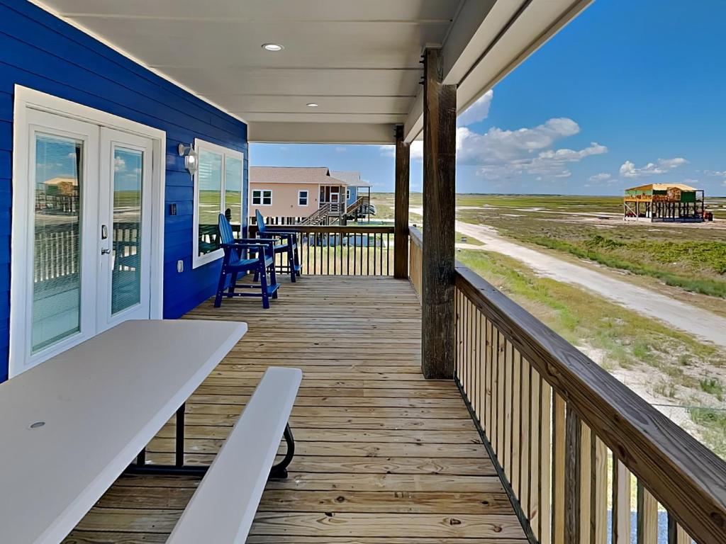a porch with a bench on a blue house at Fish Tales in Lamar