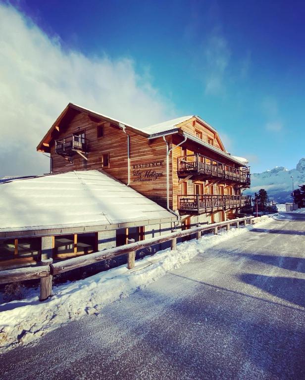 a large wooden building with snow on the ground at C03 lajoue in Le Dévoluy